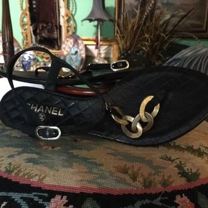 Black CHANEL sandals with gold chain.